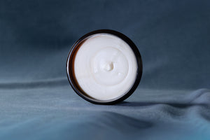The smooth white texture of Defining Cream in the open jar
